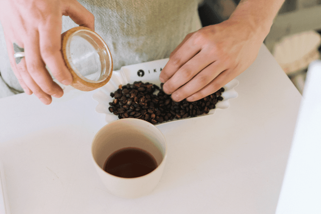 Patrik Rolf emptying roasted coffee from IKAWA collection far into cupping tray.