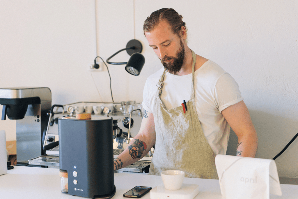 Patrik Rolf standing at bench roasting with IKAWA PRO V3 at April Coffee Roasters headquarters.